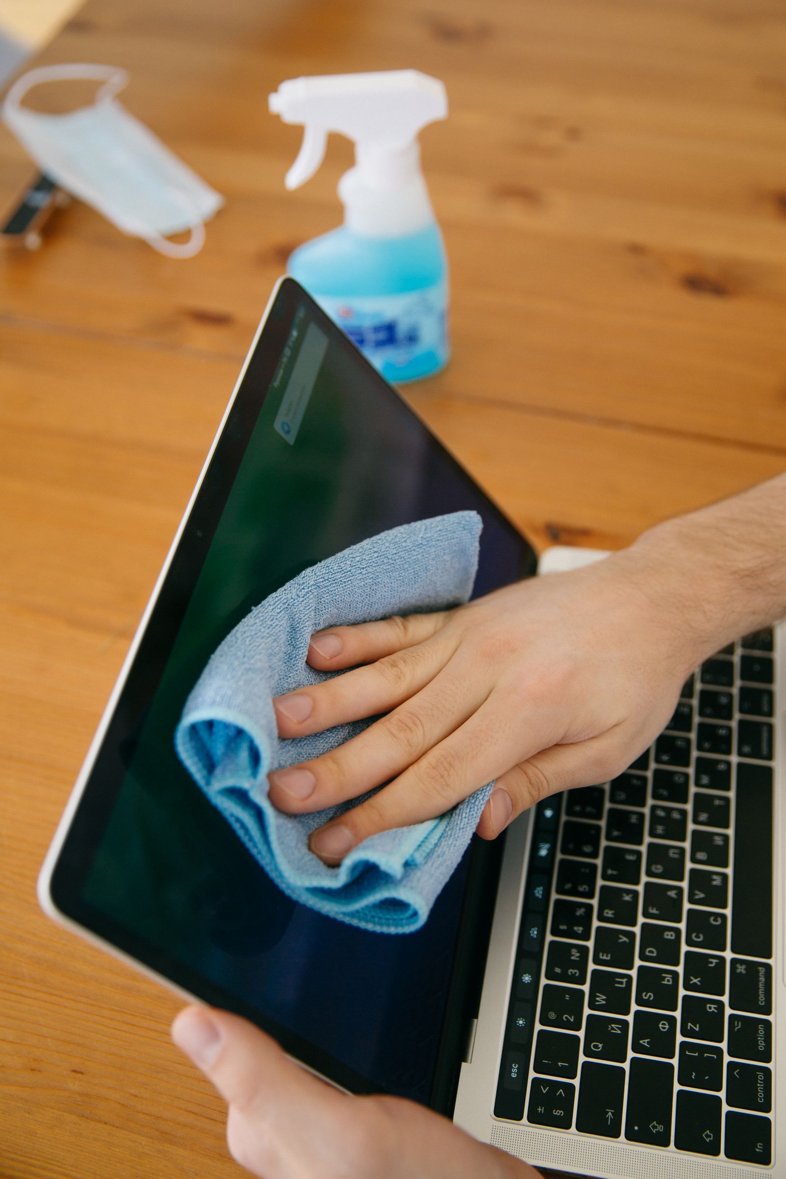 Essuyage d'un écran de poste de travail à la microfibre, dans un bureau